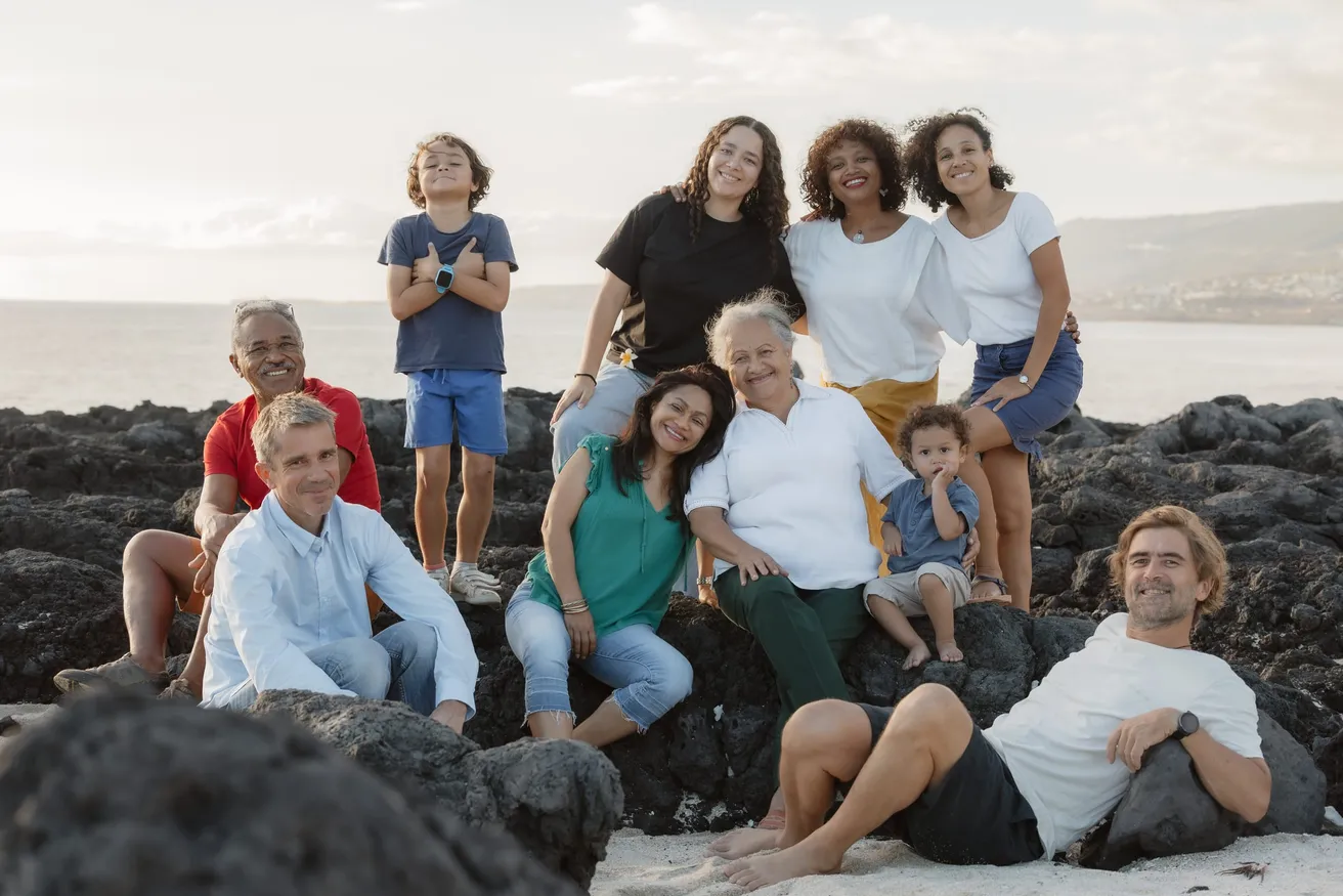 Une famille nombreuse posée sur les rochers volcaniques, la mer derrière
