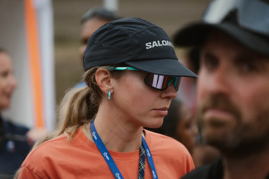 Une femme en casquette et lunettes de soleil, le regard concentré, au milieu de la foule