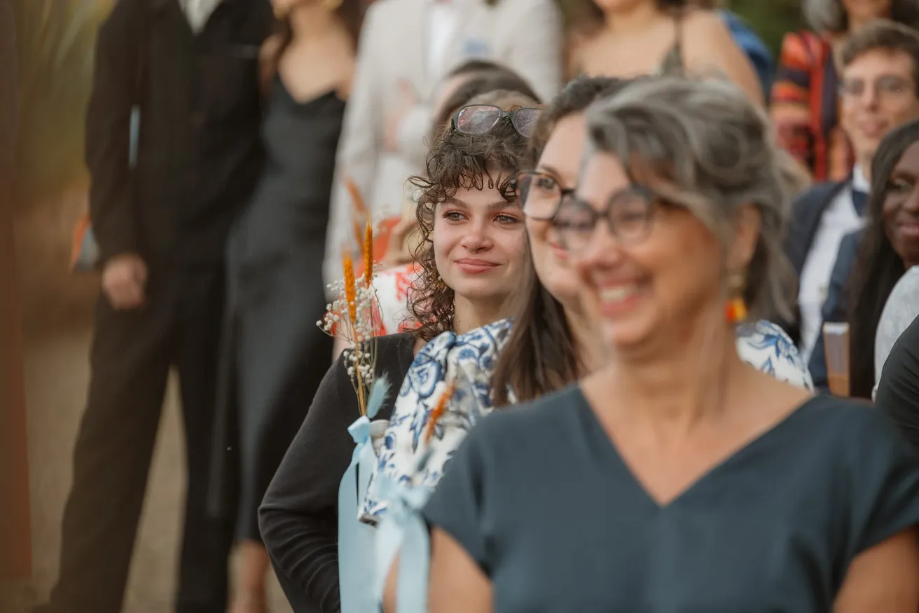 Invitées souriantes pendant la cérémonie, l’une d’elles essuie une larme