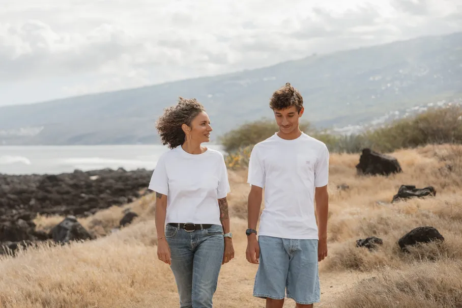 Une mère et son grand fils marchent en se regardant, parmi les rochers et les herbes sèches