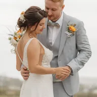 Les mariés se regardent, le bouquet à la main, dans la savane dorée