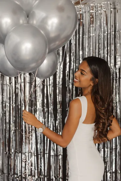 Un portrait d’anniversaire, robe blanche et bouquet de ballons argentés